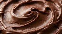 Rich creamy chocolate frosting with smooth swirls and glossy texture for baking and dessert decoration projects.