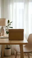 Brown cardboard package box on wooden desk in modern home office workspace with natural lighting and minimalist decor for shipping and delivery.