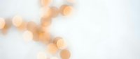 Soft golden bokeh lights creating dreamy atmosphere on white background for elegant design projects and romantic presentations.