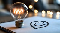 Glowing vintage light bulb with filament forming letter M next to hand-drawn smiley face on paper, with soft bokeh lights in background.