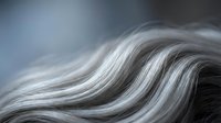 Close-up of smooth silver gray hair waves with silky texture, soft bokeh background, showcasing natural aging, hair care and beauty concepts.