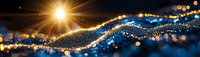 Abstract golden and blue glowing wave with light particles and bokeh effect on dark background, festive holiday concept.