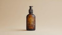 Brown glass bottle with pump dispenser covered in water drops against neutral beige background, minimalist product photography for cosmetic and spa marketing.