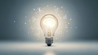 Glowing light bulb with business icons and dollar signs floating around representing innovation, creativity, and financial success in entrepreneurship.
