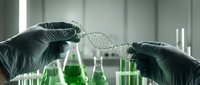 Scientist hands in gloves holding DNA double helix model in modern laboratory with green chemical solutions and test tubes for genetic research.