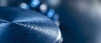 Close-up of metallic blue industrial component with precision threading and smooth curved surface showcasing manufacturing quality and engineering detail.