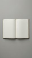 Open vintage book with blank white pages on a neutral gray background, ready for text or mockup overlay in editorial and design projects.