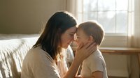 Loving mother holding toddler son in tender embrace by sunny window, gentle parenting moment in cozy bedroom with soft natural light creating warm family atmosphere.