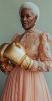 Senior African American woman in elegant pink lace dress holding golden boxing gloves, representing strength and grace. Portrait showcases confidence and defying stereotypes.