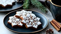 Festive snowflake gingerbread cookies with white icing on elegant black plate, cinnamon sticks and pine branches creating cozy winter holiday atmosphere.