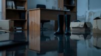Flooded office interior with water damage, submerged furniture and equipment after natural disaster or pipe burst for insurance claims documentation.