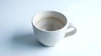Empty white ceramic coffee cup with brown stains on clean white background, isolated for design use in cafes, restaurants and beverage concepts.