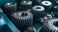 Macro view of industrial metal gears and cog wheels in dark blue tones showing mechanical engineering details and precision manufacturing components.