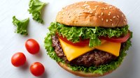 Delicious cheeseburger with beef patty, melted cheese, fresh lettuce and tomato on sesame seed bun. Perfect for restaurant menus and food advertising.