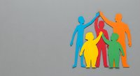 Colorful paper cutout family figures holding hands together on gray background representing unity, diversity, teamwork and community support concept.