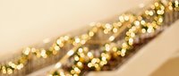 Blurred golden bokeh lights on diagonal striped surface create warm, festive atmosphere suitable for holiday backgrounds, greeting cards, and seasonal marketing materials.
