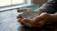 Businessman hands holding transparent holographic display with financial charts and data analytics for modern business technology presentation.