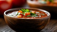 Hearty vegetable soup with fresh herbs served in wooden bowl, ready for lunch or dinner meal preparation and food photography.
