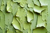 Peeling green paint texture with cracked and flaking layers creating abstract pattern on weathered surface. Macro photography reveals detailed texture and depth.