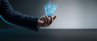 Businessman hand holding glowing digital cube with blue light effect against dark background, representing technology innovation and data management.