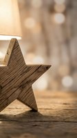 Rustic wooden star decoration on natural wood surface with warm bokeh lights creating cozy atmosphere for holiday celebrations and festive home decor projects.
