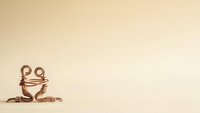Cute copper wire frog sculpture sitting on beige background with copy space for creative design projects and handmade craft concepts.