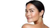 Young Asian woman with glowing natural makeup and healthy radiant skin smiling confidently against white background, beauty and skincare concept.