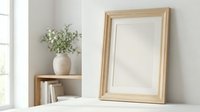 Elegant wooden picture frame mockup on shelf with ceramic vase and greenery in bright minimalist interior for home decor and design presentations.