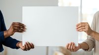 Diverse group of people holding blank white poster together, representing teamwork, collaboration, and unity in corporate or community projects.