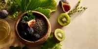 Healthy chia pudding bowl with fresh kiwi slices and figs on natural background for nutritious breakfast and wellness lifestyle concepts.