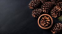 Pine cones in wooden bowl on dark background with copy space. Natural winter holiday decor elements arranged with minimalist aesthetic and moody lighting.