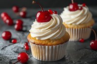 Vanilla cupcakes topped with swirled cream cheese frosting and fresh red cherries on dark background, selective focus on front dessert with scattered berries.