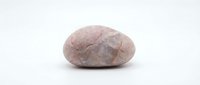 Single pink granite stone with natural texture and smooth surface isolated on white background for design projects and decorative applications.