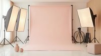 Professional photography studio setup with softbox lighting equipment and pink backdrop for commercial photo shoots and creative projects.