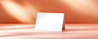 Blank white greeting card mockup on coral pink background with soft window shadows. Clean minimalist design for branding presentation.