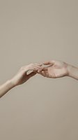 Two hands gently reaching and touching fingertips against a neutral beige background, symbolizing connection, love, and human bond.