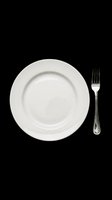 Empty white plate with silver fork isolated on transparent background, ready for dining design, restaurant graphics, menu layouts, t-shirt designs, and print-on-demand products.