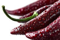 Fresh red chili peppers with water drops on dark surface, extreme macro photography showing detailed texture and moisture on glossy skin surface.