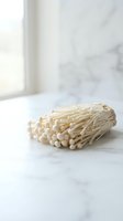 Bunch of wooden cotton swabs with round tips arranged on marble surface near window, isolated for design, craft, hygiene, and beauty product applications.