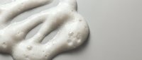 White creamy cosmetic texture with bubbles and foam for skincare beauty products and spa treatments on neutral background.