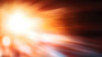 Dramatic orange and black abstract background with light streaks and bokeh effects creating dynamic motion blur and glowing energy movement pattern.