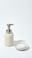 Minimalist cream ceramic soap dispenser with stainless steel pump and matching dish isolated on white background for bathroom decor and hygiene products.