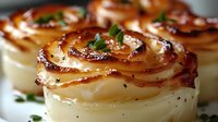 Golden potato roses with crispy caramelized edges and fresh herbs, gourmet side dish for fine dining restaurants and culinary presentations.