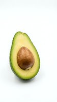 Fresh avocado half with pit isolated on white background for healthy eating and cooking designs.