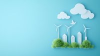 Paper art cityscape with wind turbines and green plants against blue background showcasing sustainable urban development and renewable energy concept.