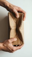 Male hands holding empty brown leather wallet open, showing no money inside. Concept for financial hardship, bankruptcy, poverty, and economic crisis situations.