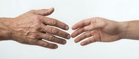 Two hands reaching toward each other in helping gesture on white background, symbolizing support, assistance, and human connection for business concepts.