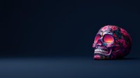 Pink decorative skull with floral pattern on dark background, dramatic side lighting creates mysterious atmosphere. Artistic interpretation for Day of Dead celebration.