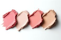 Smeared makeup powder samples in pink and nude shades arranged in row on white background, cosmetic texture swatches for beauty industry and makeup artists.
