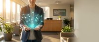 Professional businessman holding glowing digital hologram in modern office lobby representing innovation technology and future business solutions.